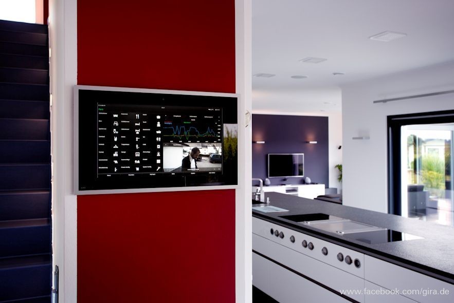 Modern inredning av ett allrum med öppen planlösning, med ett finrum, vita väggar och en väggmonterad TV