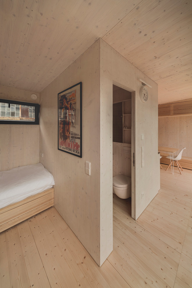 Foto de salón abierto actual pequeño con suelo de madera clara