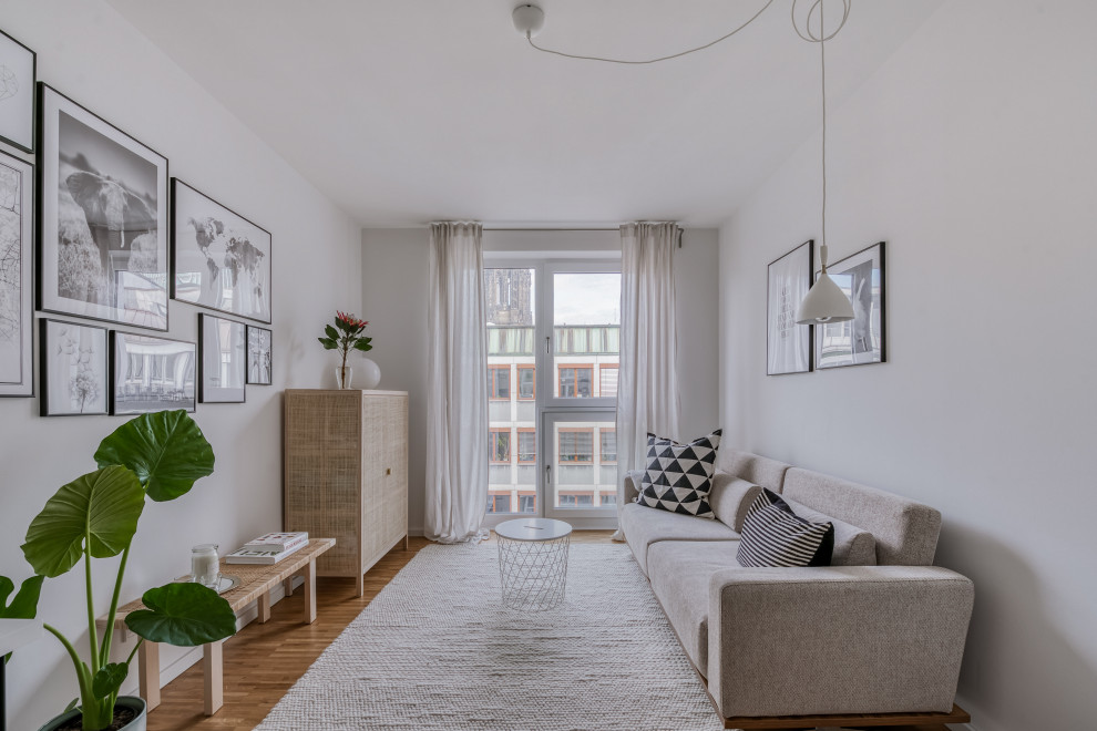 Skandinavisches Wohnzimmer mit weißer Wandfarbe, beigem Boden und hellem Holzboden in Hamburg