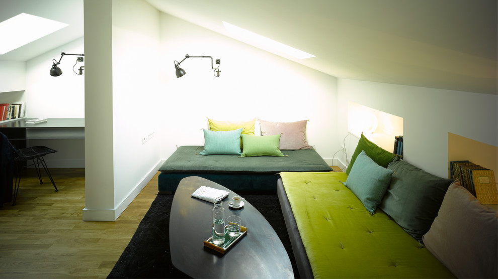 Réalisation d'une petite salle de séjour design ouverte avec un mur blanc, un sol en bois brun et aucune cheminée.