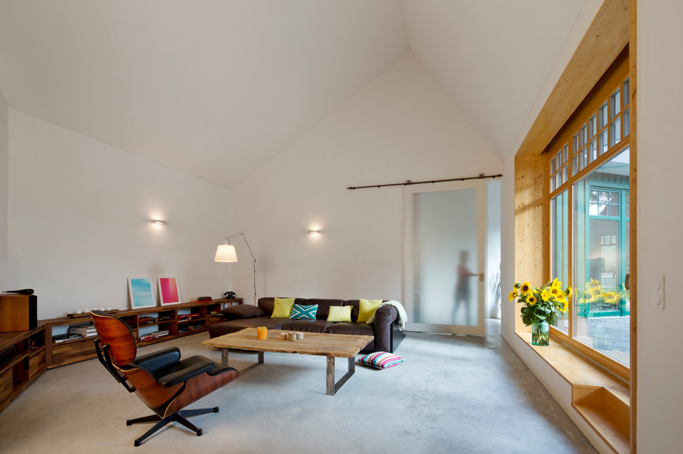 Idee per un grande soggiorno minimal chiuso con pareti bianche, pavimento in cemento e nessun camino