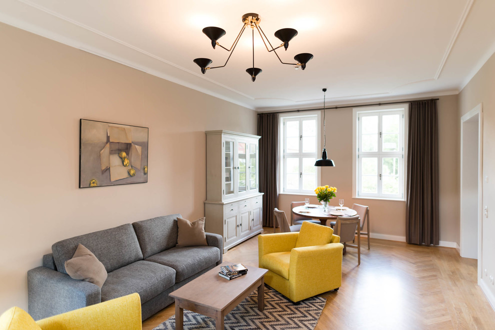 Ejemplo de sala de estar cerrada tradicional renovada grande sin chimenea y televisor con paredes beige, suelo de madera en tonos medios y suelo marrón