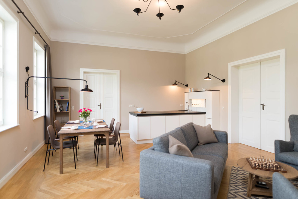 Diseño de salón abierto actual de tamaño medio sin chimenea y televisor con paredes beige, suelo de madera en tonos medios y suelo marrón