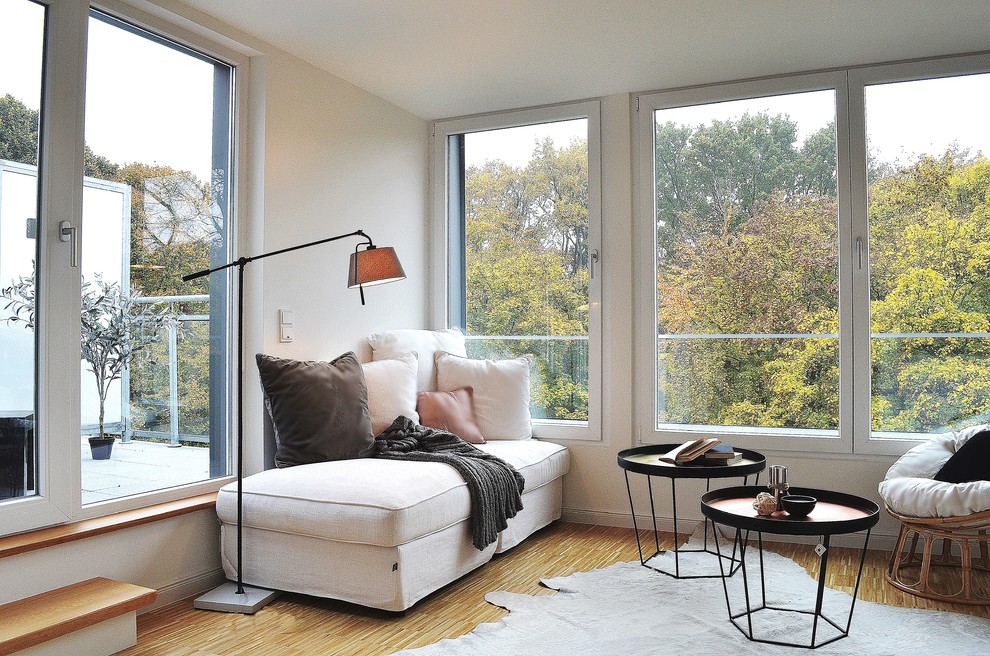 На фото: маленькая гостиная комната в стиле неоклассика (современная классика) с белыми стенами и паркетным полом среднего тона для на участке и в саду с