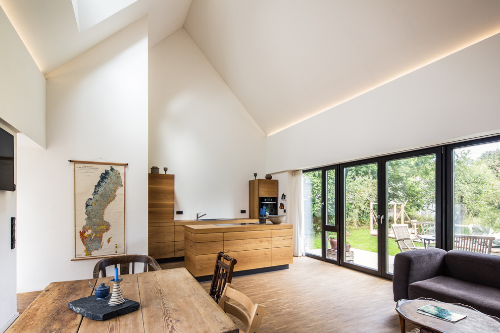 Idee per un ampio soggiorno minimal aperto con pareti bianche e parquet chiaro
