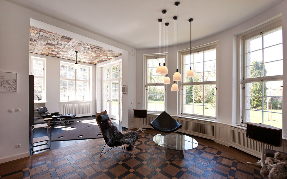Esempio di un ampio soggiorno minimal aperto con pareti bianche e pavimento in legno massello medio