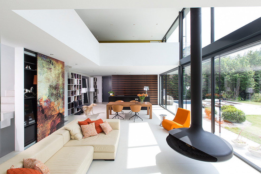 Источник вдохновения для домашнего уюта: открытая гостиная комната в современном стиле с белыми стенами, подвесным камином и фасадом камина из металла