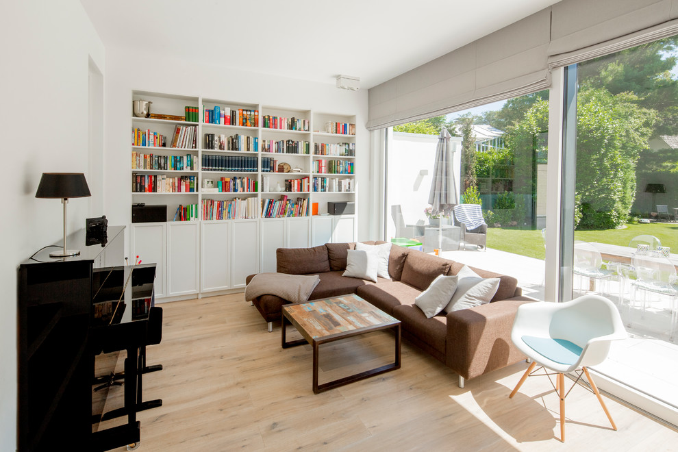 Inspiration for a mid-sized contemporary open concept medium tone wood floor and beige floor living room library remodel in Dusseldorf with white walls, a ribbon fireplace, a metal fireplace and a media wall