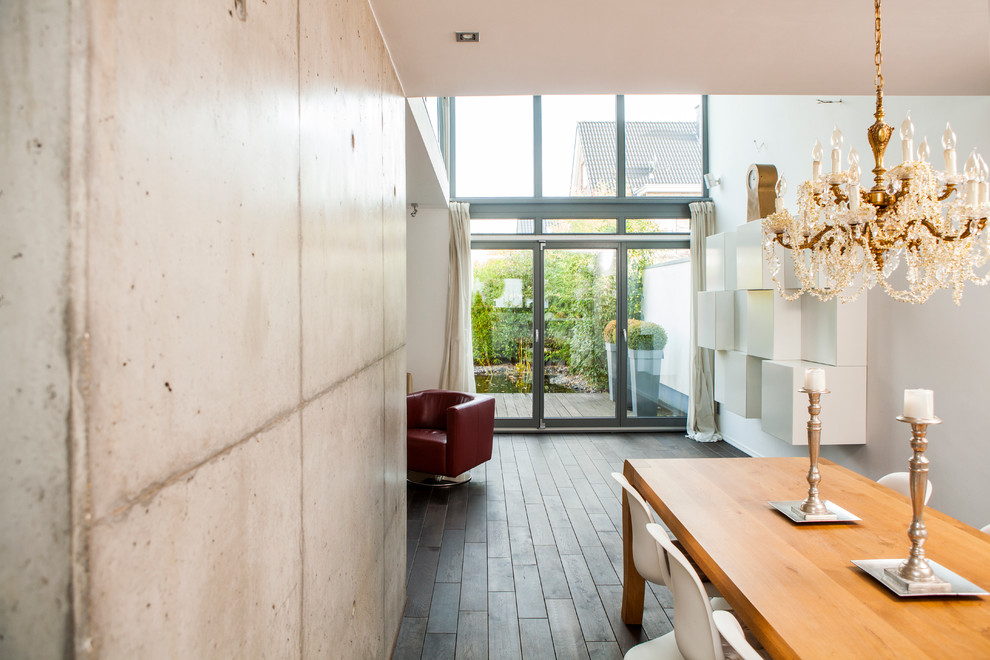 Cette image montre une très grande salle de séjour minimaliste ouverte avec un mur blanc, parquet peint, une cheminée d'angle, un manteau de cheminée en plâtre et un sol marron.