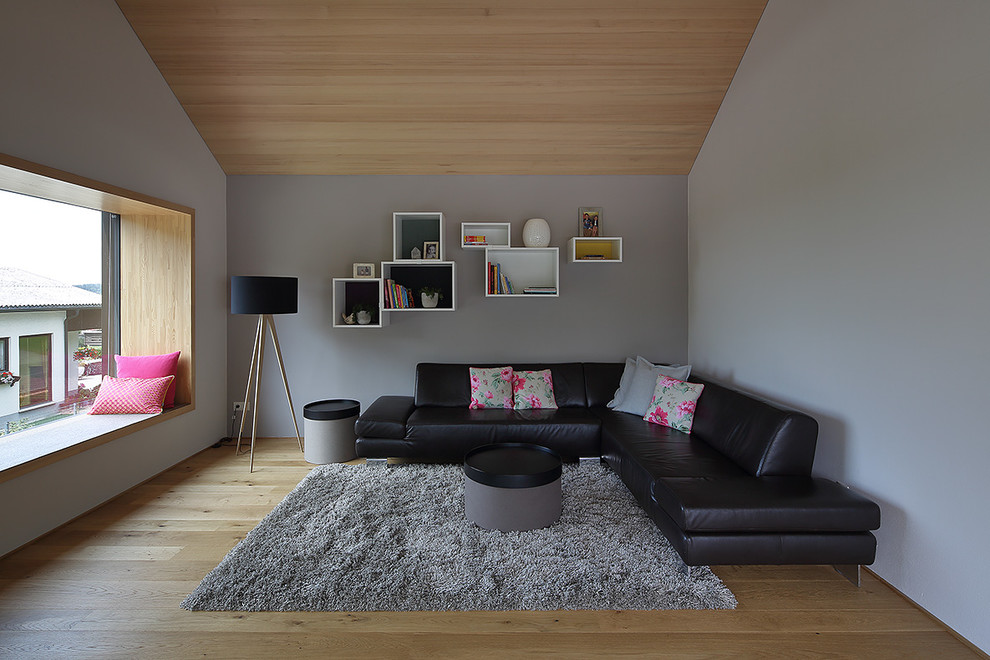 Foto di un soggiorno design di medie dimensioni e chiuso con pareti grigie, pavimento in legno massello medio e nessun camino