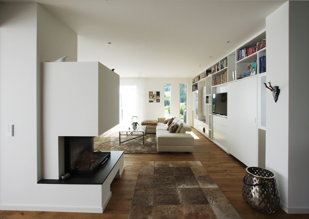 Aménagement d'un grand salon contemporain ouvert avec un mur blanc, un sol en bois brun, une cheminée standard, un manteau de cheminée en plâtre et un téléviseur indépendant.