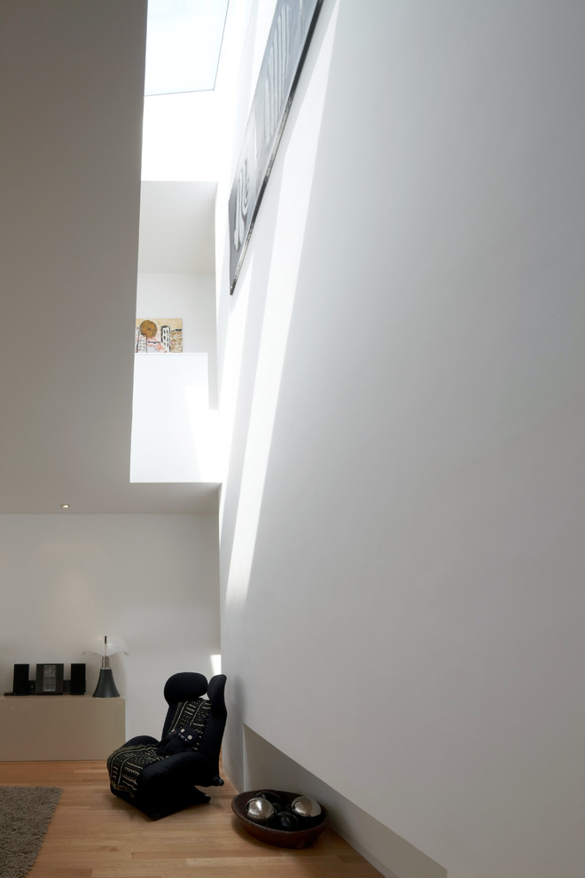 Großes, Repräsentatives, Fernseherloses, Offenes Modernes Wohnzimmer ohne Kamin mit weißer Wandfarbe, braunem Holzboden und braunem Boden in Köln