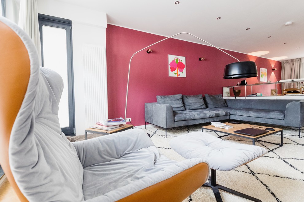 Пример оригинального дизайна: открытая гостиная комната среднего размера в современном стиле с красными стенами, паркетным полом среднего тона и коричневым полом