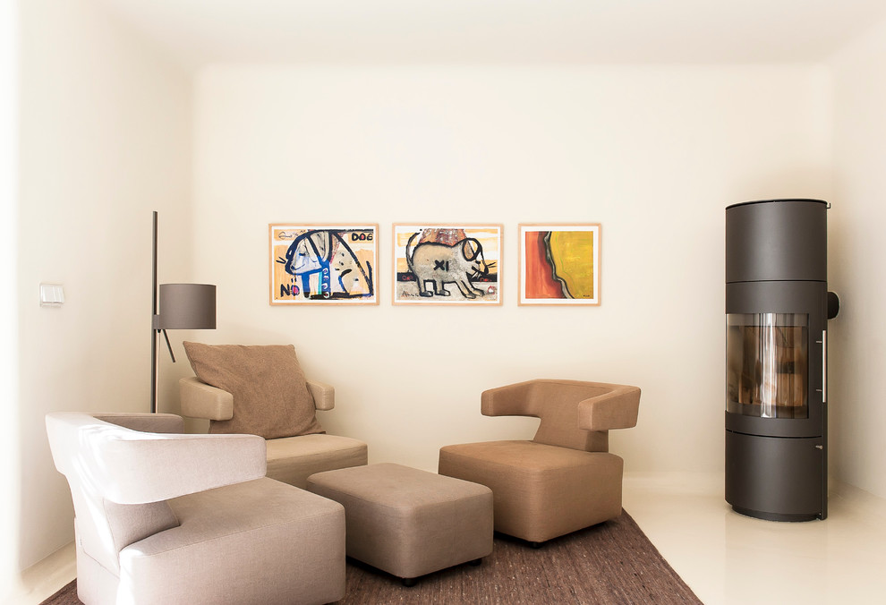 ハンブルクにある高級な中くらいなエクレクティックスタイルのおしゃれなLDK (白い壁、コンクリートの床、金属の暖炉まわり、薪ストーブ、テレビなし) の写真