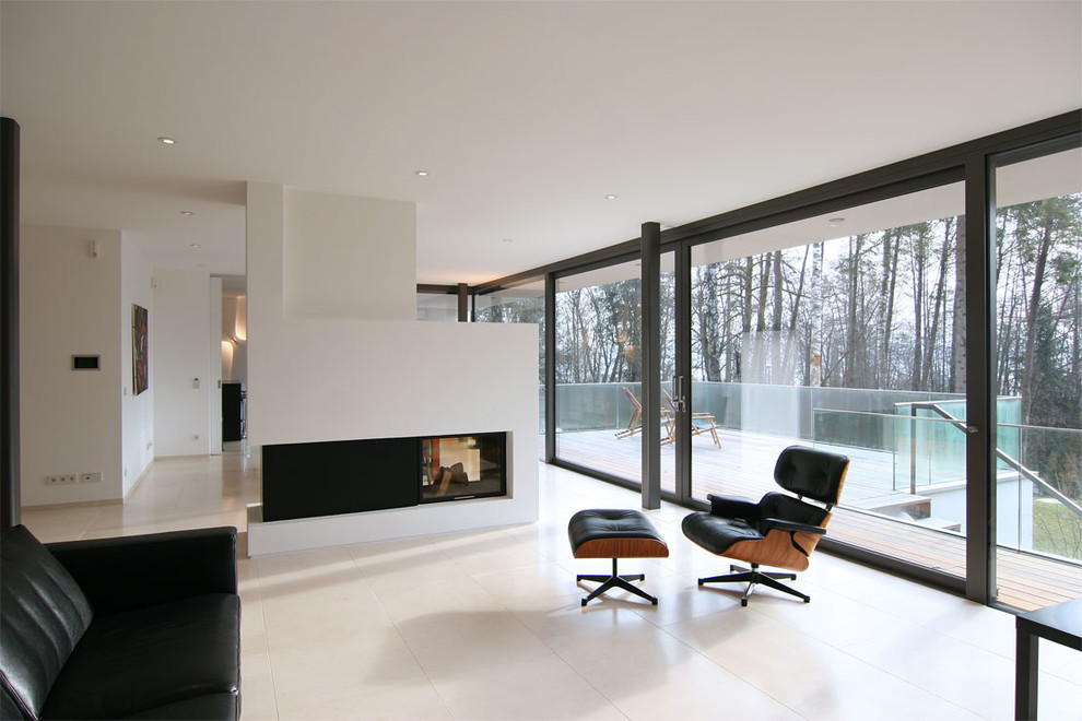 Imagen de salón para visitas abierto minimalista de tamaño medio con paredes blancas, chimenea de doble cara y marco de chimenea de yeso