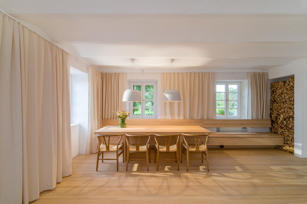 Imagen de comedor nórdico grande con paredes blancas y suelo de madera clara
