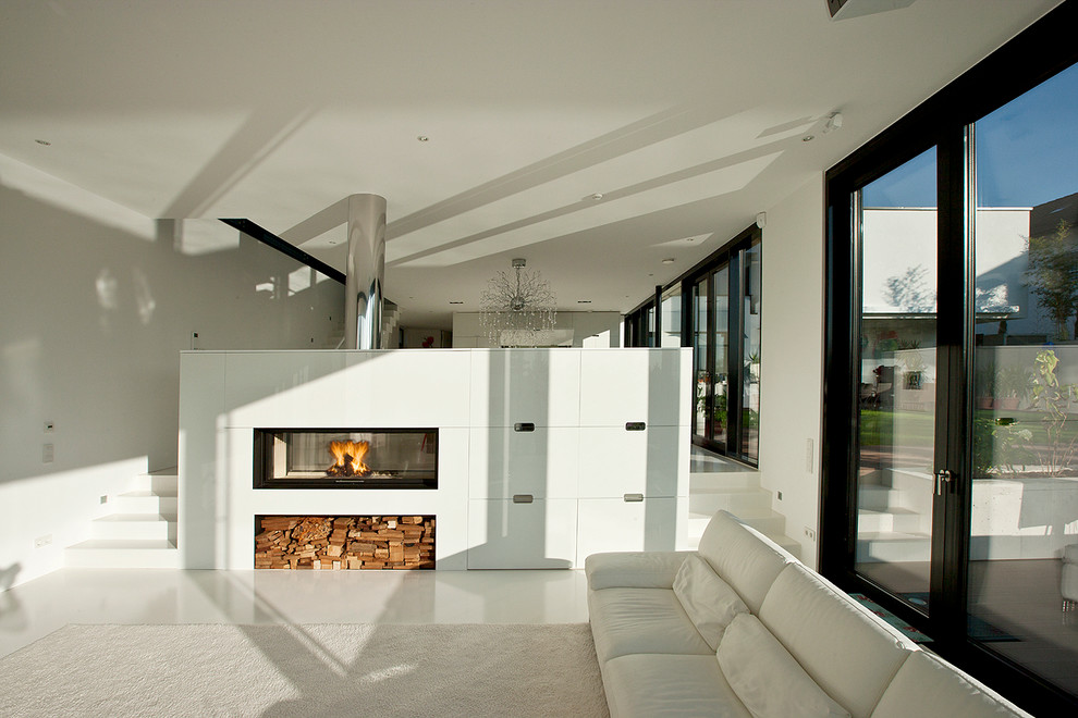 Стильный дизайн: большая открытая гостиная комната в современном стиле с белыми стенами и двусторонним камином - последний тренд