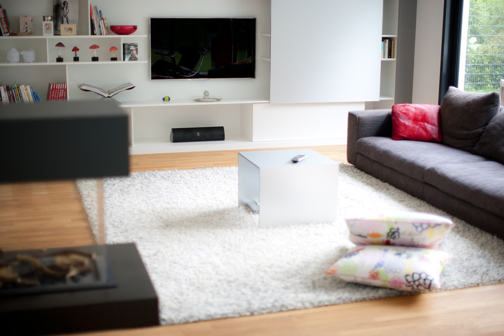 Foto di un soggiorno moderno aperto con pareti bianche e TV a parete