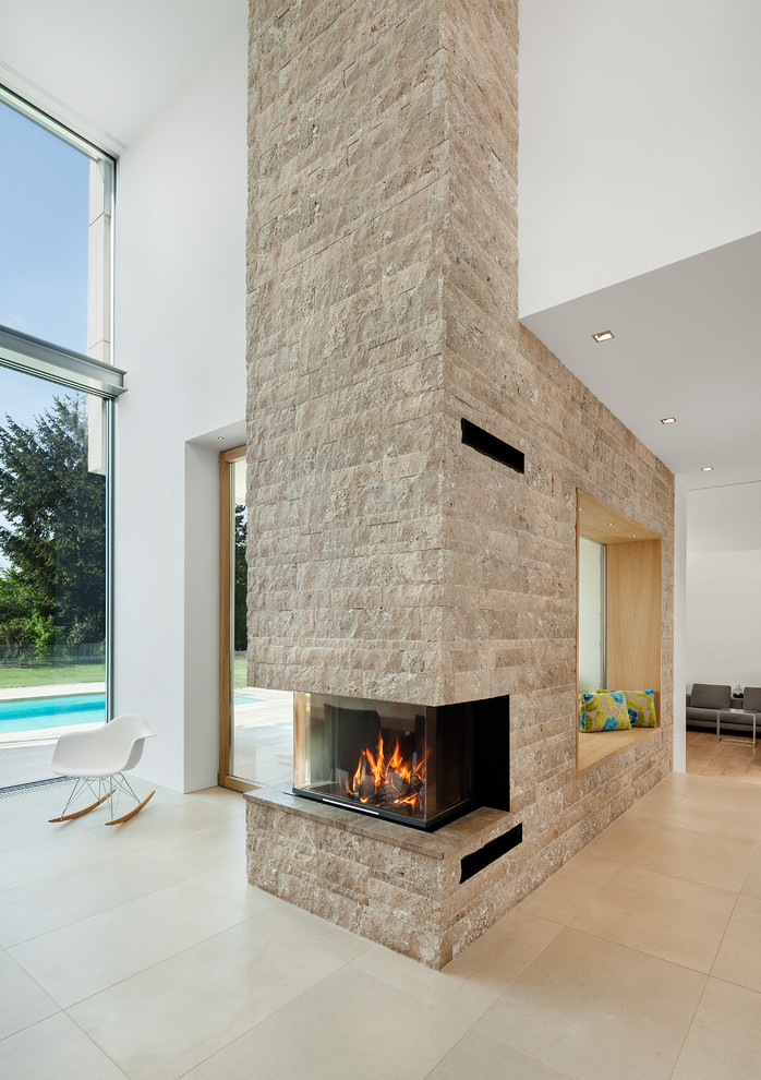 Réalisation d'un salon design ouvert avec un mur blanc, un manteau de cheminée en pierre, une cheminée d'angle, un mur en pierre et éclairage.