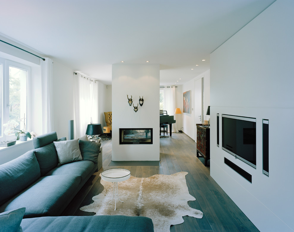 Großes, Offenes Modernes Wohnzimmer mit weißer Wandfarbe, dunklem Holzboden, Tunnelkamin, verputzter Kaminumrandung und Multimediawand in Sonstige