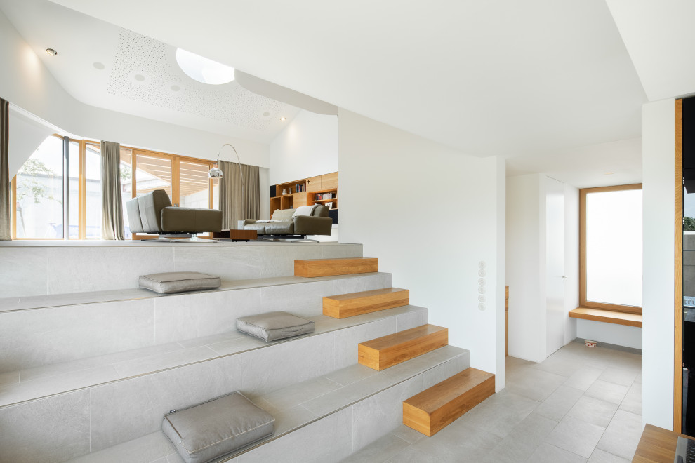 Diseño de salón para visitas abierto contemporáneo extra grande con paredes blancas, suelo de baldosas de porcelana y suelo gris