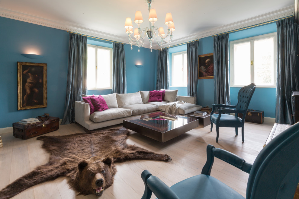 Ispirazione per un soggiorno tropicale di medie dimensioni con pareti blu, pavimento in legno massello medio e pavimento marrone