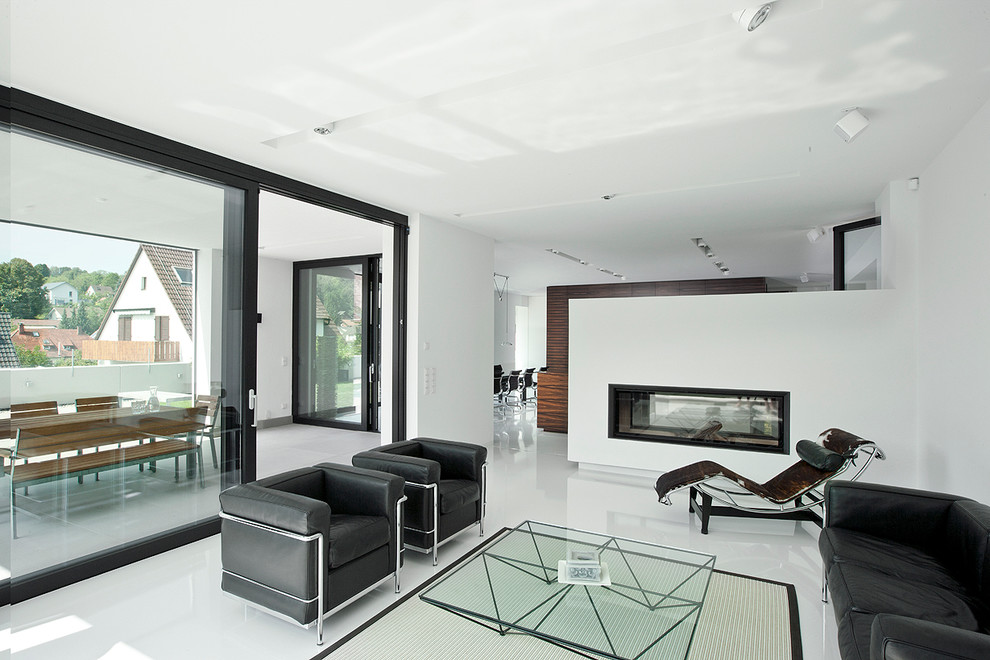 Großes, Offenes Modernes Wohnzimmer mit weißer Wandfarbe, Tunnelkamin, verputzter Kaminumrandung und Keramikboden in Sonstige