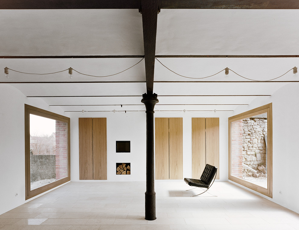 На фото: открытая гостиная комната в стиле модернизм с белыми стенами, фасадом камина из штукатурки и двусторонним камином с