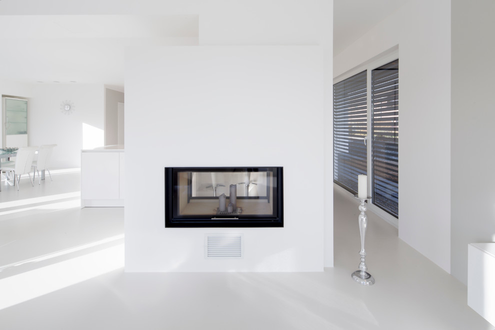 Imagen de sala de estar abierta contemporánea grande con paredes blancas, chimenea de doble cara y marco de chimenea de yeso