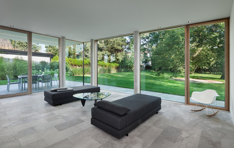 Esempio di un soggiorno moderno di medie dimensioni e aperto con pareti bianche e pavimento in pietra calcarea