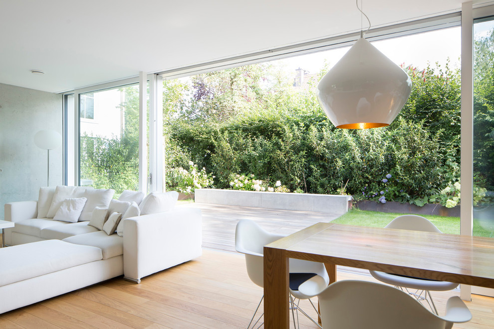 Ispirazione per un soggiorno eclettico aperto e di medie dimensioni con pareti bianche e parquet chiaro