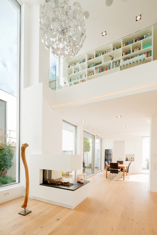 Großes, Offenes Modernes Wohnzimmer mit weißer Wandfarbe, braunem Holzboden, Gaskamin, verputzter Kaminumrandung und beigem Boden in Düsseldorf