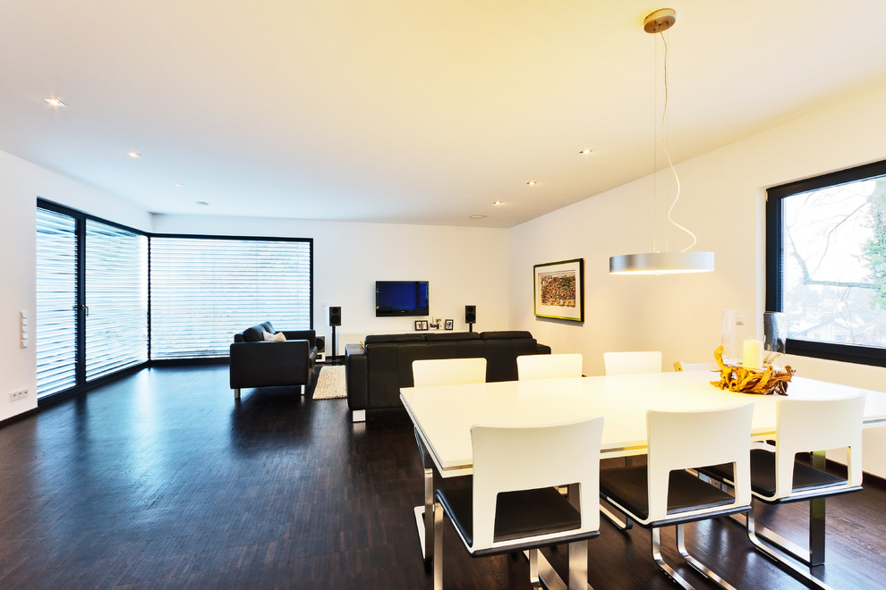Ejemplo de salón abierto contemporáneo de tamaño medio con paredes blancas, suelo de madera oscura y televisor independiente
