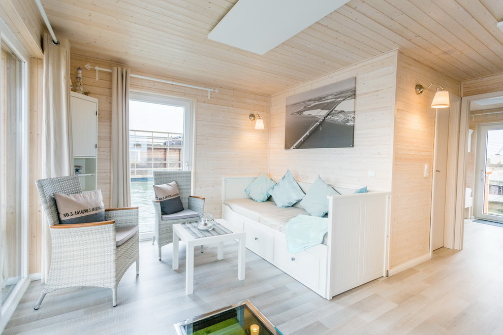 Offenes, Repräsentatives Maritimes Wohnzimmer mit weißer Wandfarbe, Laminat, TV-Wand und grauem Boden in Hamburg