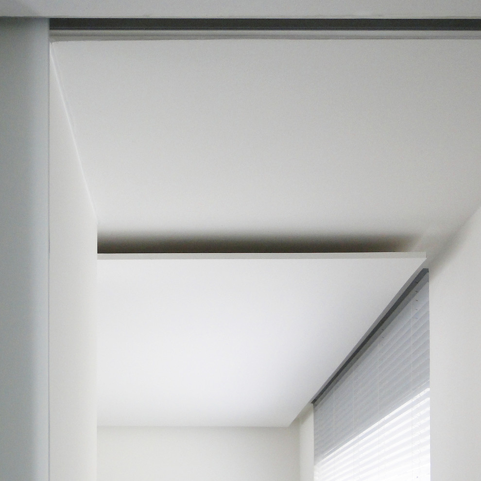 Bild på ett mellanstort funkis allrum med öppen planlösning, med ett finrum, vita väggar, mörkt trägolv, en standard öppen spis, en spiselkrans i gips och brunt golv
