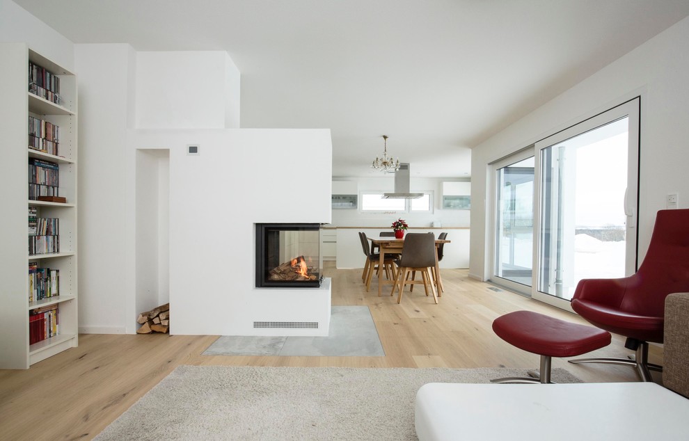 Photo of a large contemporary open plan living room in Stuttgart with white walls, light hardwood flooring, a two-sided fireplace, a plastered fireplace surround, a reading nook, no tv and beige floors.