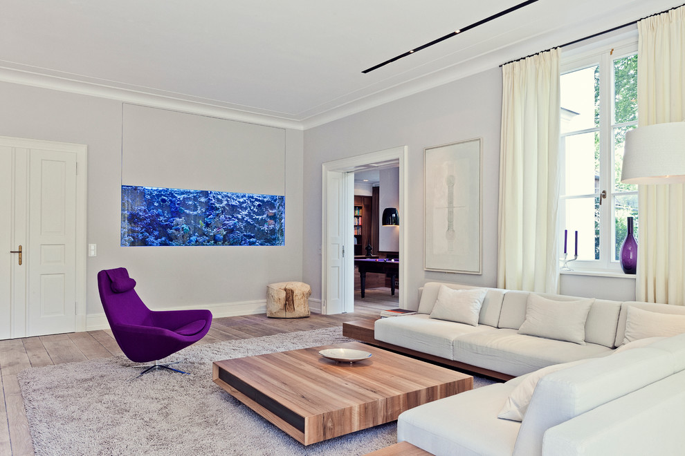 Abgetrenntes, Mittelgroßes, Fernseherloses Modernes Wohnzimmer ohne Kamin mit beiger Wandfarbe und gebeiztem Holzboden in Essen