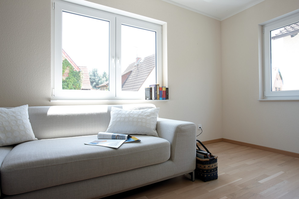 Modernes Wohnzimmer ohne Kamin mit beiger Wandfarbe, hellem Holzboden und braunem Boden in Sonstige