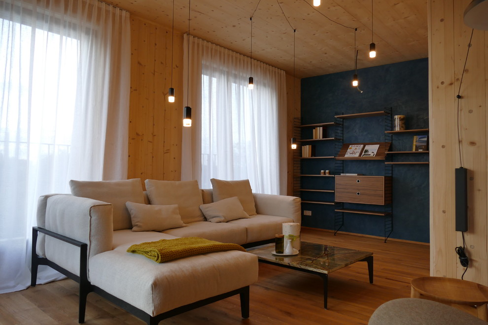 Mittelgroße, Fernseherlose, Abgetrennte Moderne Bibliothek ohne Kamin mit blauer Wandfarbe, hellem Holzboden und braunem Boden in Berlin