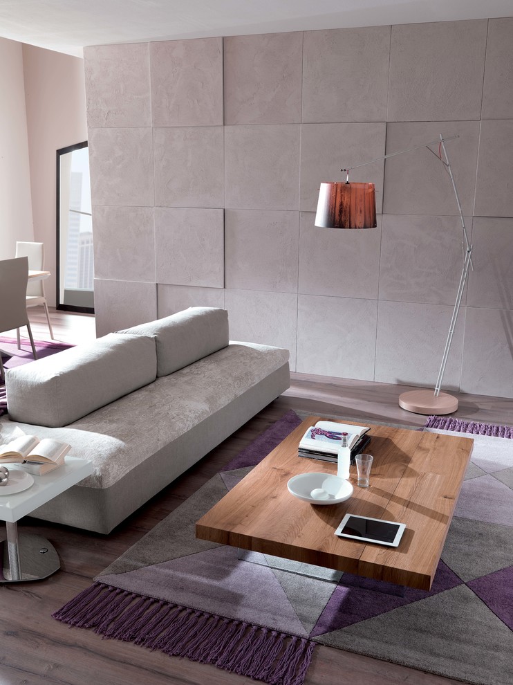 Modelo de sala de estar con biblioteca abierta contemporánea grande sin chimenea y televisor con paredes blancas, suelo de cemento, suelo gris y marco de chimenea de ladrillo