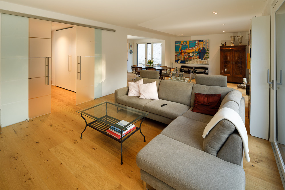 Modernes Wohnzimmer mit weißer Wandfarbe und hellem Holzboden in Düsseldorf