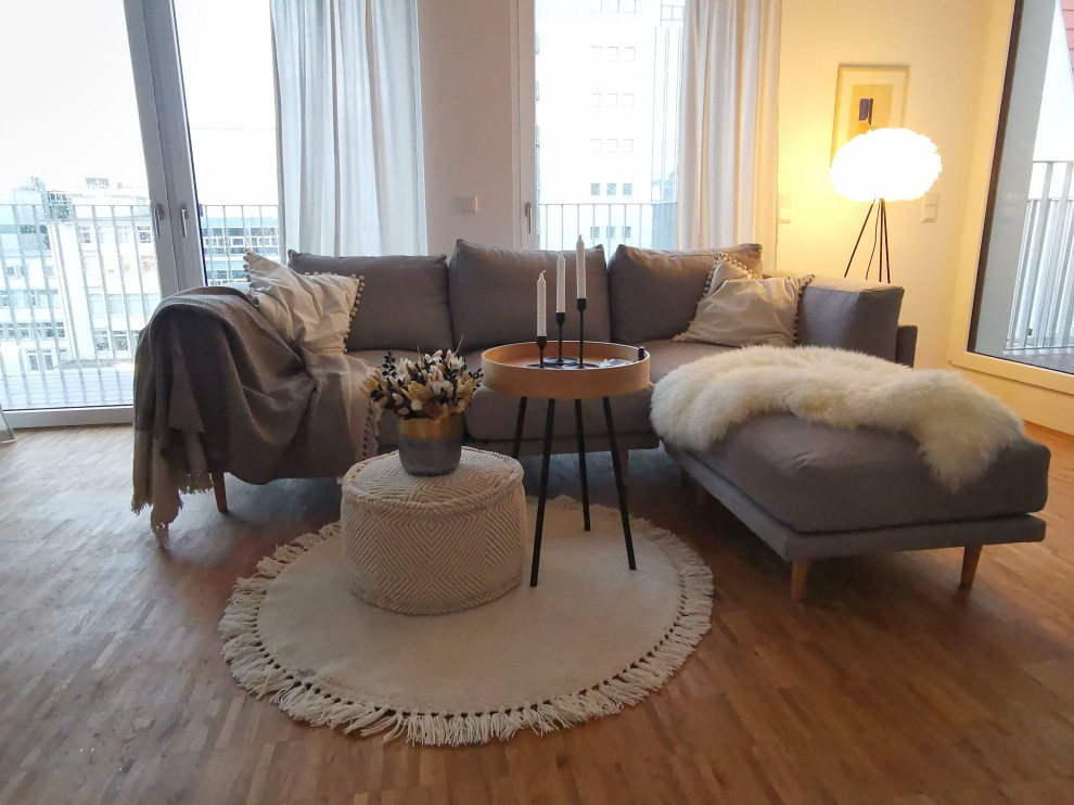 Imagen de sala de estar abierta nórdica de tamaño medio con paredes blancas y suelo de madera en tonos medios
