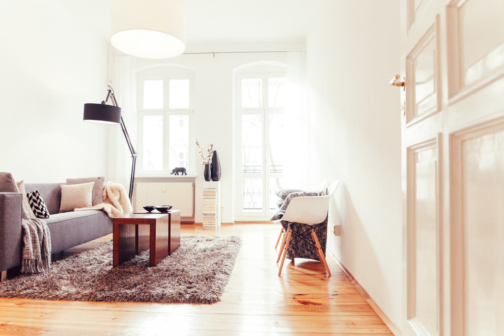 Immagine di un ampio soggiorno scandinavo con pareti bianche e parquet chiaro