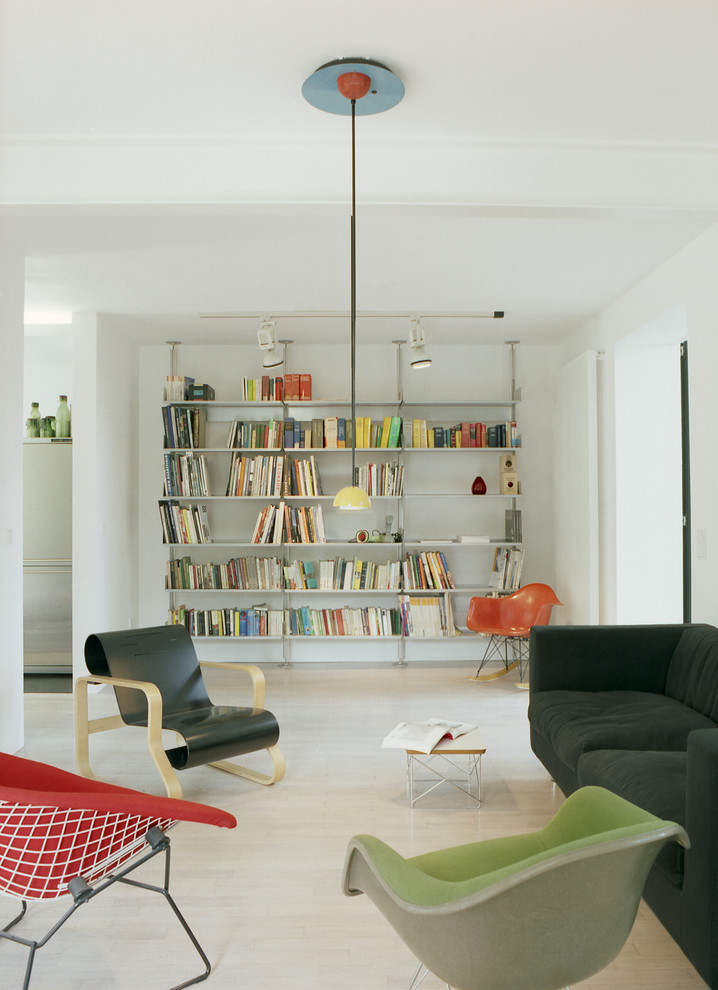 Ejemplo de biblioteca en casa actual de tamaño medio sin chimenea y televisor con paredes blancas y suelo de madera clara