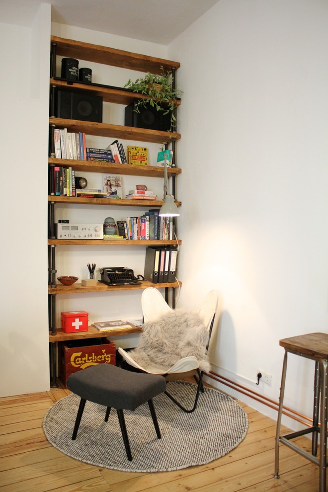 Diseño de sala de estar urbana sin chimenea con paredes blancas y suelo de madera en tonos medios