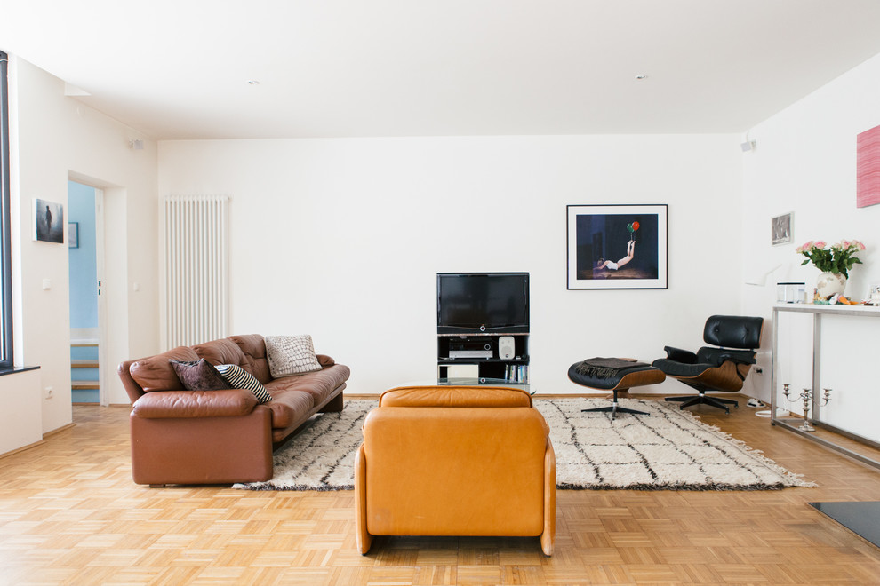 Foto de salón cerrado bohemio de tamaño medio sin chimenea con paredes blancas, suelo de madera en tonos medios y televisor independiente