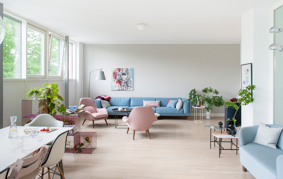 Nordisches Wohnzimmer mit beiger Wandfarbe, braunem Holzboden und braunem Boden in Berlin
