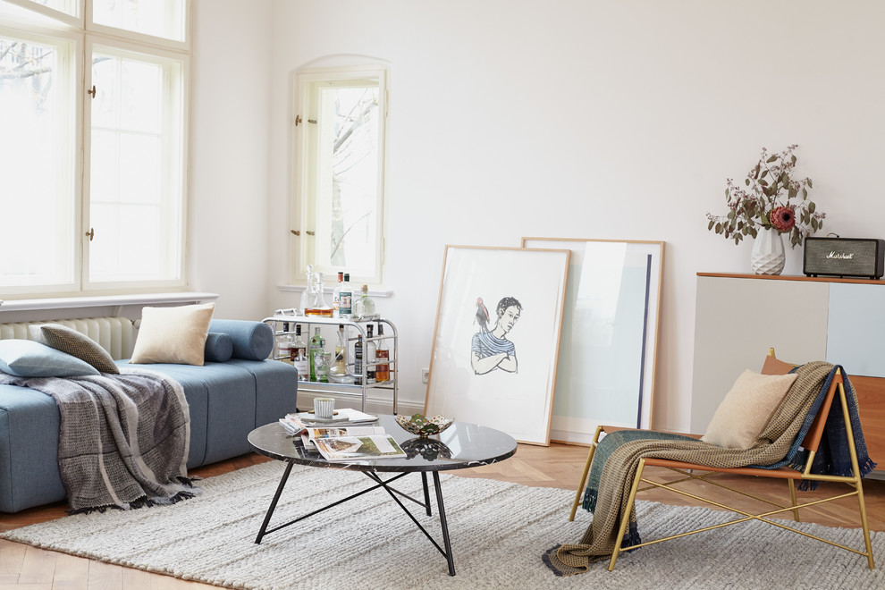 Immagine di un soggiorno scandinavo di medie dimensioni con pareti bianche, pavimento in legno massello medio e pavimento marrone