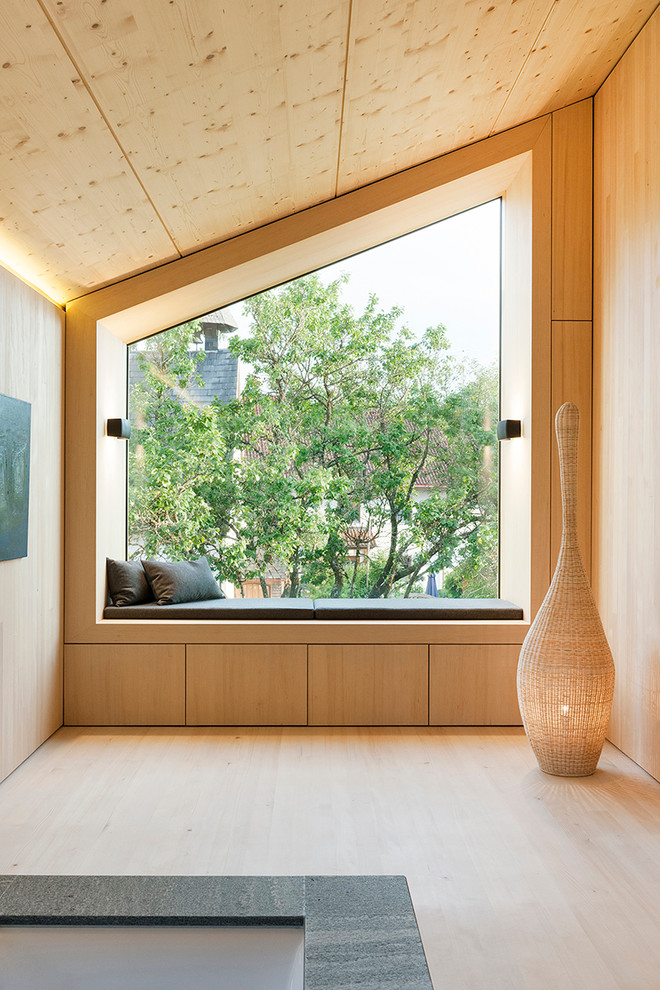 Imagen de salón abierto contemporáneo pequeño sin chimenea con paredes beige y suelo de madera clara