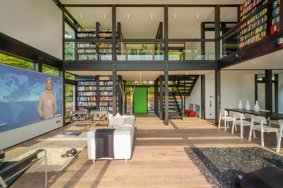 Immagine di un ampio soggiorno contemporaneo stile loft con libreria, parquet scuro, parete attrezzata e pavimento marrone